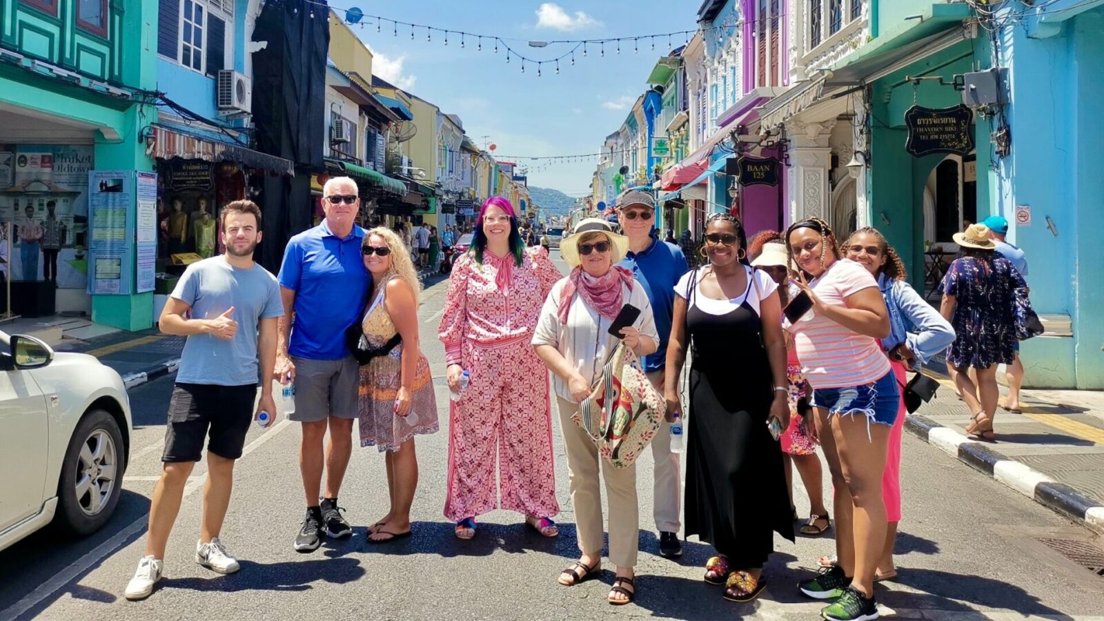 Visitors exploring colorful heritage shophouses along Thalang Road in Old Phuket Town