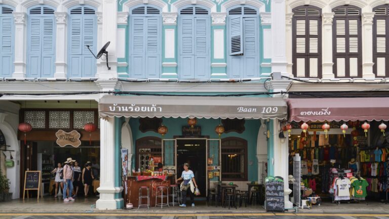 Tourists walking past a café in Phuket Old Town