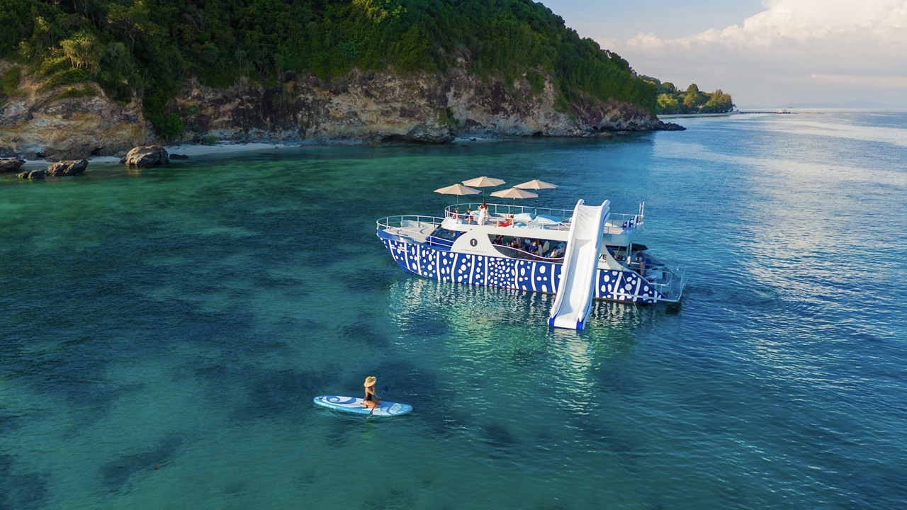 Speedboat passing clear blue water beside tropical islands