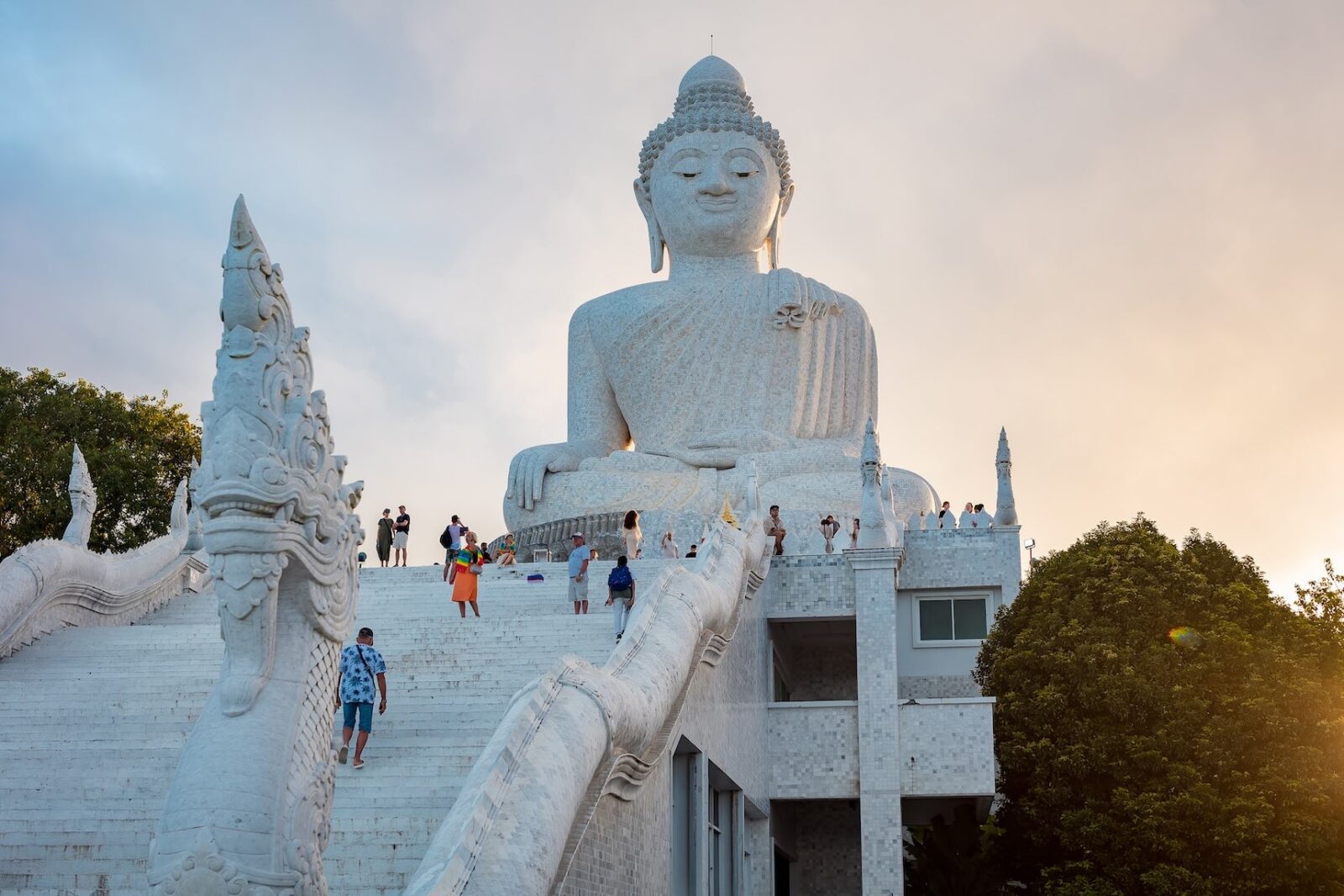Visitors overlooking the coastline from a hilltop temple viewpoint in Phuket