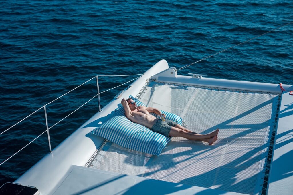 Guest relaxing on a catamaran trampoline over the sea in Phuket